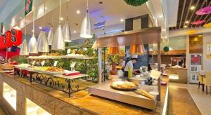 a buffet line in a restaurant with food on display at Inzone Garlnd Hotel Zhangqiu in Jinan