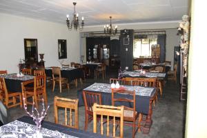 a dining room with tables and chairs in a restaurant at Makarios Lodge in Polokwane