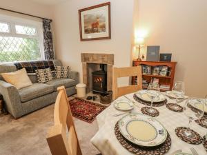a living room with a table and a fireplace at Appletree Cottage in Richmond