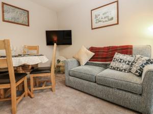 a living room with a couch and a table at Appletree Cottage in Richmond