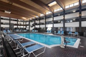 a pool in a hotel with chairs and tables at DoubleTree by Hilton Manhattan, KS in Manhattan