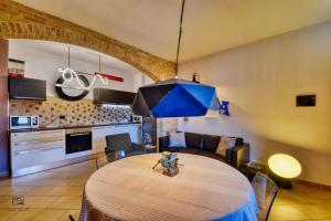 a dining room with a table and a blue umbrella at InCorteDaFabio Design flat with Bikes in Caronno Pertusella +3 photos