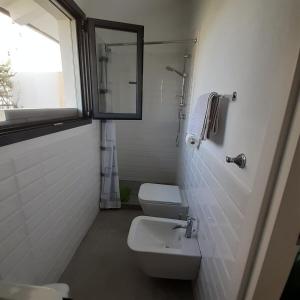 Un baño blanco con inodoro y ventana. en Charming seaside nest, en Rímini