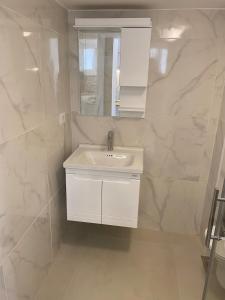 un bagno bianco con lavandino e specchio di Smart Home a Baabda Altre 10 foto