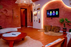 un soggiorno con un tavolo e una TV a parete di The Getaway Resort a Kado