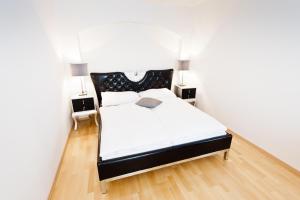 a bedroom with a black and white bed and two lamps at VOX Design Hotel in Vienna