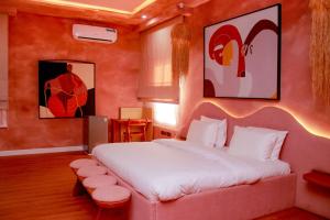 una camera da letto con un grande letto bianco e uno sgabello di The Getaway Resort a Kado