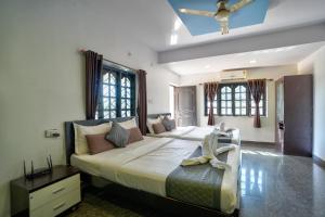 a large bedroom with a large bed and windows at Beach Edge Calangute in Calangute