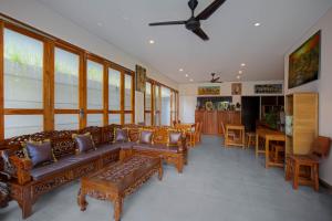a living room with couches and tables and a ceiling fan at Villa Rose 1 Sanur in Sanur