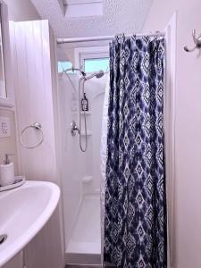 a bathroom with a shower curtain and a sink at The Riverstone Getaway in historical Madison, IN in Madison