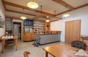 a restaurant with tables and a kitchen with a counter at Penzion Růže in Humpolec