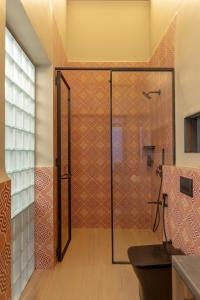 a bathroom with a shower with a glass door at Scarlatta in Ghoti Budrukh