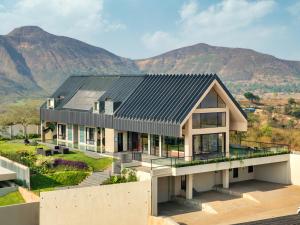 an aerial view of a house with mountains in the background at Scarlatta in Ghoti Budrukh