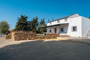 a white building with a stone wall next to it at Valle Verde in Morón de la Frontera