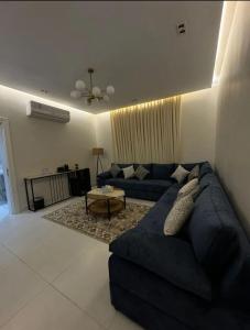 a living room with a blue couch and a table at شقة هادئة بصالة وغرفة نوم in Jeddah
