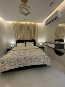 a bedroom with a large bed and a air conditioner at شقة هادئة بصالة وغرفة نوم in Jeddah