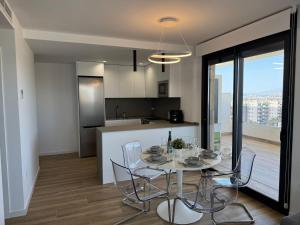 a kitchen and dining room with a table and chairs at Luxurious 2-Bedroom Apartment in Arenals del Sol with Pool and Sea Views in Arenales del Sol