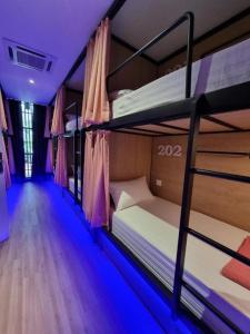 two bunk beds in a room with blue lights at Laman Green Hotel @ Seksyen 7 in Kampong Padang Jawa