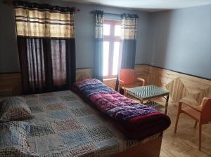 a bedroom with a bed with a quilt on it at Snow Peaks View Home Stay in Gondla
