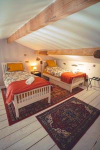 a bedroom with two beds and a rug at Le Petit Gite du Roy in Courlay