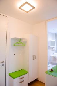 una habitación con un armario blanco con un mostrador verde en Slovenia Crib, en Liubliana
