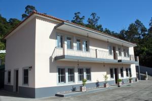 duży biały budynek z doniczkami przed nim w obiekcie Casa Os Manos w mieście Santana