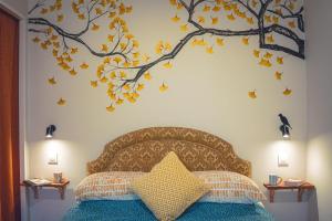 a bedroom with a bed with a tree mural on the wall at Le Petit Gite du Roy in Courlay