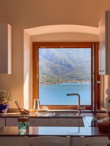 a kitchen window with a view of the water at La Suite del Faro - HelloElba in Portoferraio
