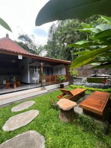 a garden with two benches and a table at Pondok Sayan Homestay in Ubud
