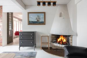 un soggiorno con camino e un dipinto di una nave di Kotimaailma Rooms - Ankkuri 2hh a Kotka