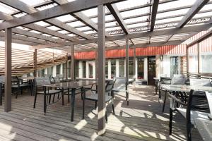 un patio con tavoli e sedie su una terrazza in legno di Kotimaailma Rooms - Ankkuri 2hh a Kotka