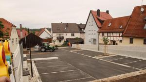 a tractor parked in a parking lot with houses at Pension Maintal Eltmann in Eltmann