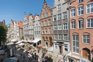 a city street with buildings and people walking around at Mariacka Apartments in Gdańsk