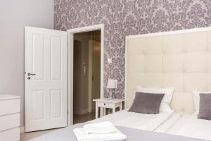 a bedroom with two white beds and a mirror at Mariacka Apartments in Gdańsk