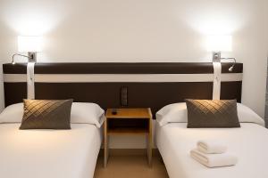 two beds sitting next to each other in a room at HOSTAL LAS PALOMAS in Lucena