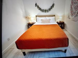 a bedroom with a bed with an orange blanket at Cozy hotels in Monterrey