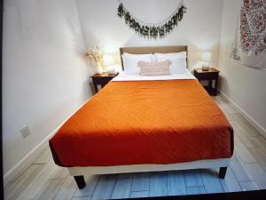 a bedroom with a large bed with an orange blanket at Cozy hotels in Monterrey