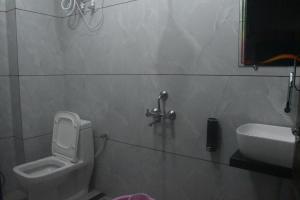 a bathroom with a toilet and a sink at Hotel Khatushyamji in Rīngas
