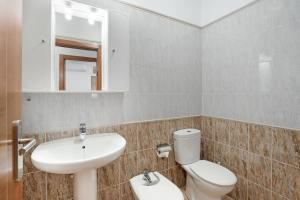 Un baño con lavabo, inodoro y espejo. en Casa Volcán y Mar 2 Derecha, en Playa de San Juan 19 fotos más