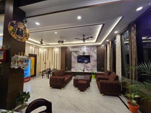 a lobby with couches and a tv on a wall at prabh aasra in Ayodhya +29 photos