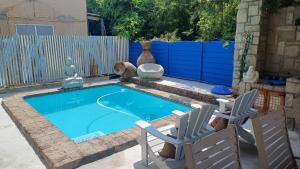 a small swimming pool with two chairs and a fence at Guesthouse TiinTiin in Potchefstroom