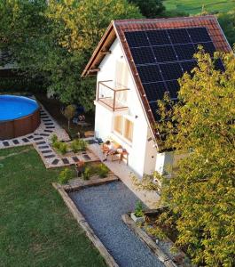 a dog sitting in front of a house with solar panels at Private Pool & Sun Terrace Pet Friendly Holiday Home in Grabovnica