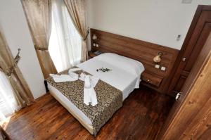 a bedroom with a bed with white towels on it at Paperon Butik Otel in Erdemli