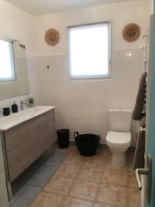 une salle de bain avec un lavabo et des toilettes et une fenêtre dans l'établissement Villa Mapokia 2 , climatisée, proche Uzès, 3 étoiles de France, à Saint-Marcel-de-Carreiret