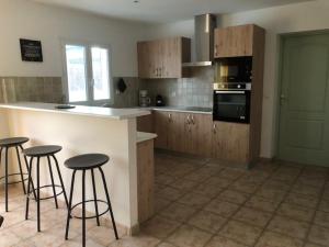 - une cuisine avec un comptoir et des tabourets de bar dans l'établissement Villa Mapokia 2 , climatisée, proche Uzès, 3 étoiles de France, à Saint-Marcel-de-Carreiret