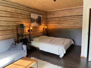 ヴィリャンディにあるLoghouse by the lakeのベッドとソファのある寝室