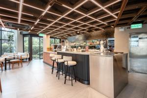a restaurant with a bar with stools at WE HOTEL RIVERFRONT in Bang Su