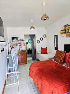a bedroom with a red bed and a ladder in it at Magalies B&B LANGENHOVENPARK in Universitas