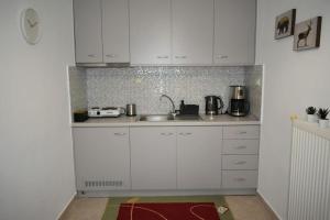 a kitchen with white cabinets and a sink at Avli Guesthouse 