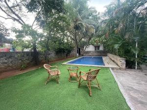 a yard with three chairs and a swimming pool at Varsha's Nest at Uthandi in Chennai